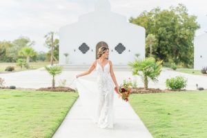 a woman in a wedding dress holding a bouquet of flowers. La Palmilla event space and planning