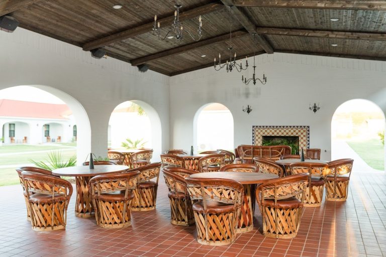 a room at la palmilla resort with tables and chairs