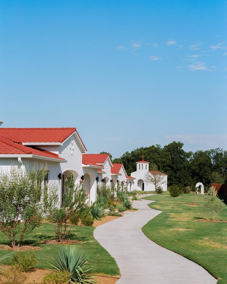 a white buildings with red roofs. La Palmilla resort walkway